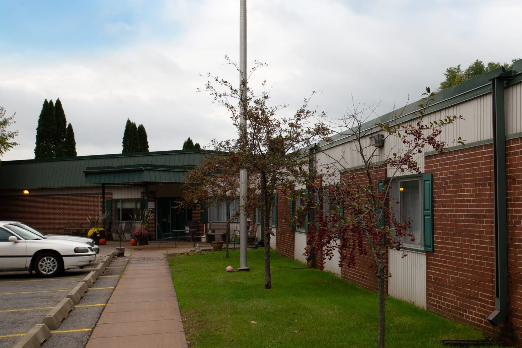The main entrance of La Crescent Healthcare, with its covered walkway and tree-lined approach